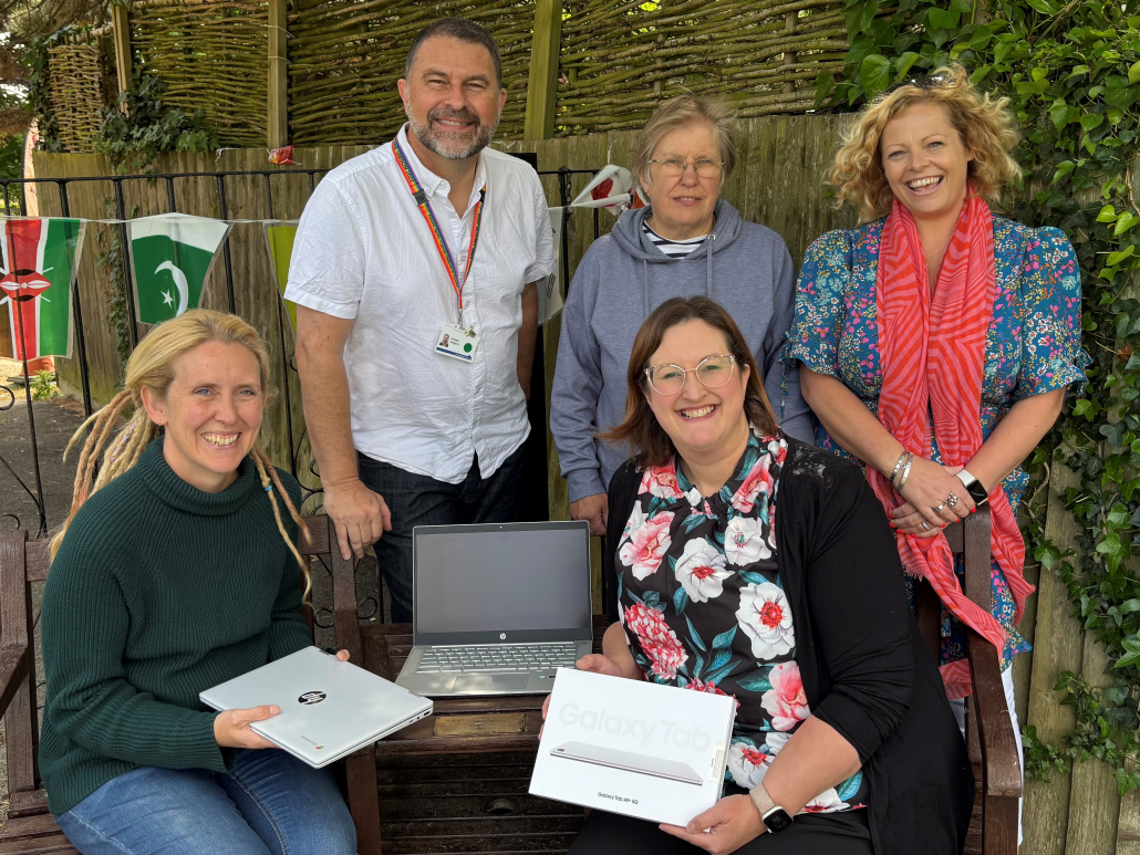 A group of people holding laptops and tablets.