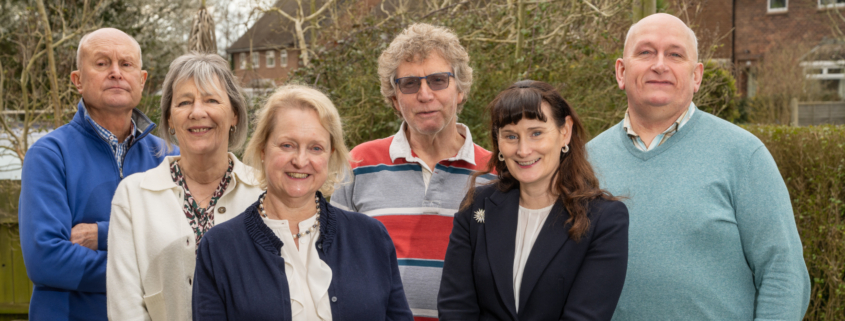 6 Trustees standing outside on a spring day