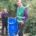 A blond lady wearing waders in the river with a gentleman holding a blue bin bag on the bank